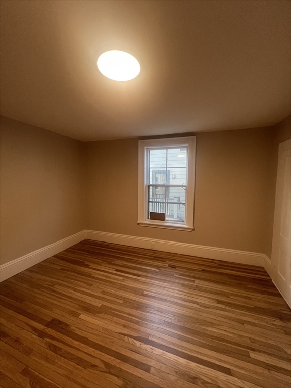15 Harris Street, Unit 2 Marblehead, MA 01945 - Photo 12 of 19 a view of an empty room with wooden floor and a window