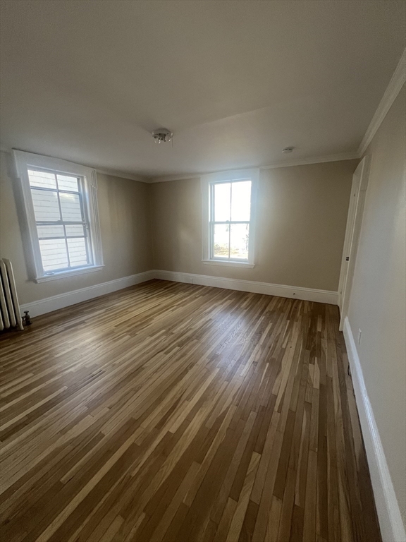 15 Harris Street, Unit 2 Marblehead, MA 01945 - Photo 14 of 19 an empty room with wooden floor and windows
