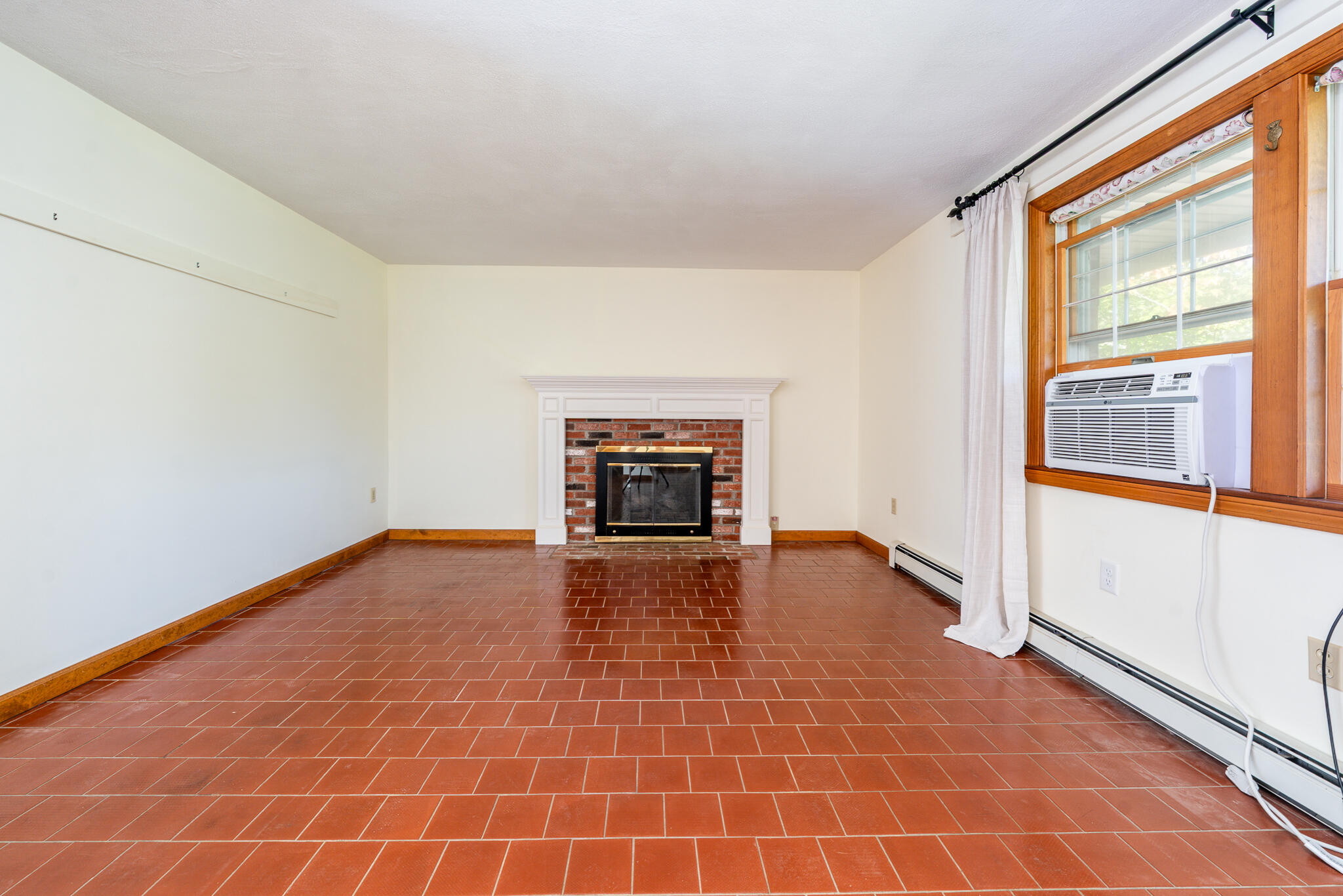 115 Sparrow Hawk Lane Eastham, MA 02642 - Photo 3 of 30 a view of empty room with wooden floor and fireplace