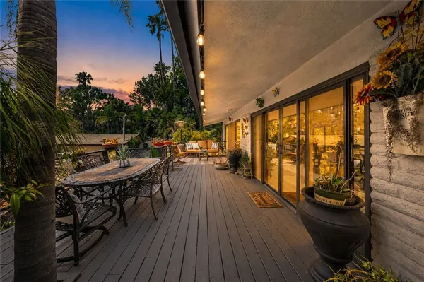 a balcony with wooden floor table and chairs