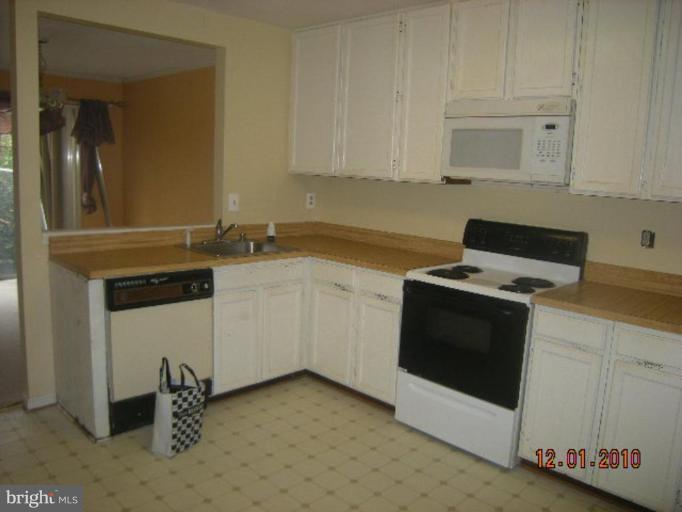 6947 Mayfair Terrace Laurel, MD 20707 - Photo 3 of 5 a kitchen with granite countertop white cabinets and white appliances
