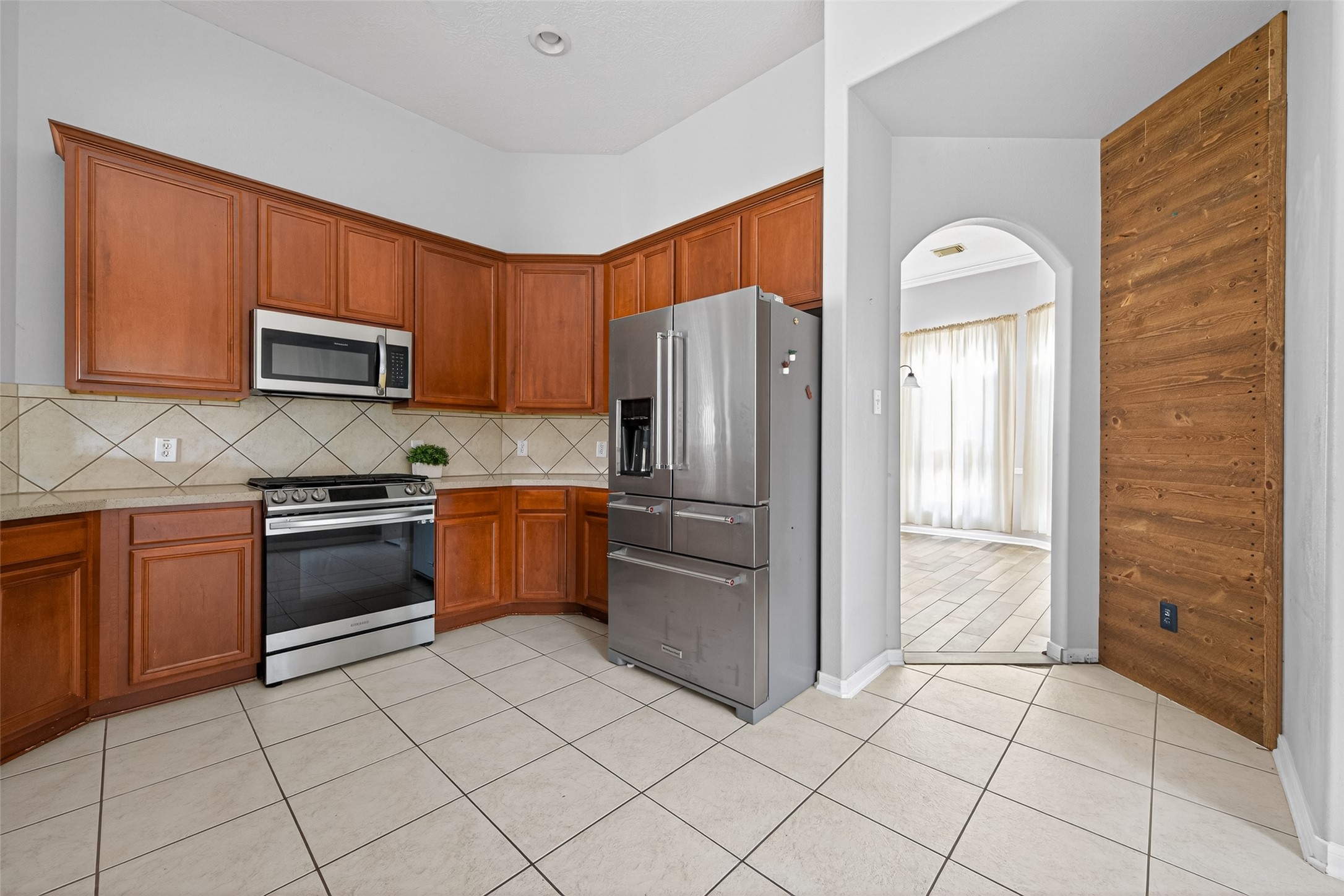 20827 Rose Crossing Lane Spring, TX 77379 - Photo 12 of 50 a kitchen with granite countertop a refrigerator and a stove top oven