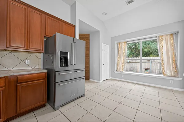a view of an empty room with wooden floor fireplace and a window