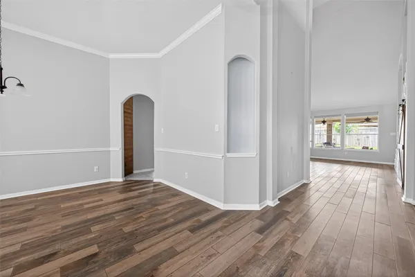 a view of an empty room with window and wooden floor