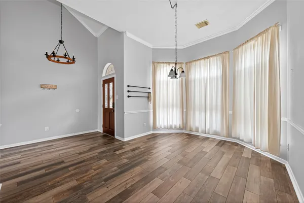 a view of a hallway with wooden floor and a chandelier