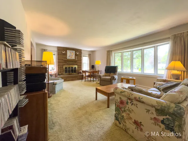 a living room with furniture and a flat screen tv with kitchen view