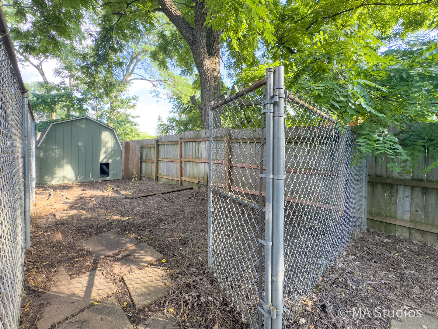 1219 Golf Lane Wheaton, IL 60189 - Photo 58 of 67 a view of a backyard with large trees and wooden fence