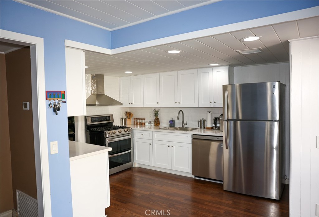 2216 El Capitan Drive Riverside, CA 92506 - Photo 7 of 39 a kitchen with a refrigerator a stove top oven and wooden floor