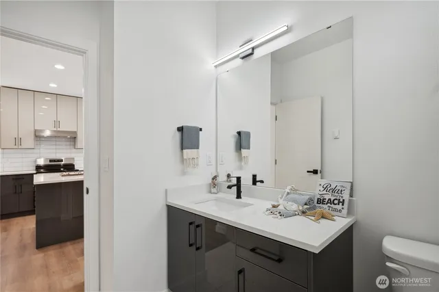 a bathroom with a sink toilet double vanity and tub