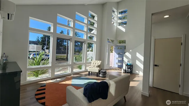 a living room with fireplace furniture and a large window