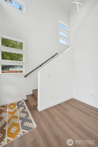 a view of a big room with wooden floor and windows