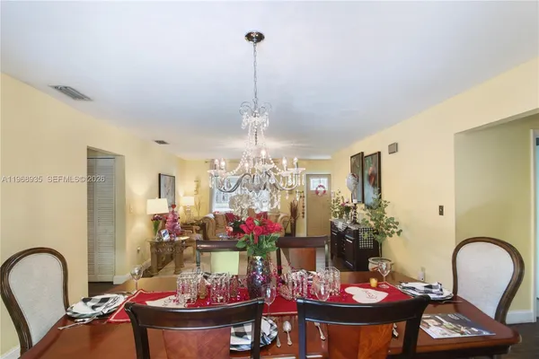 a view of a dining room with furniture and chandelier