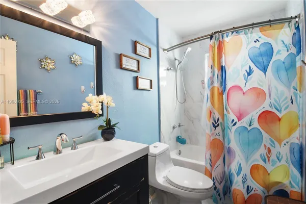 a bathroom with a sink mirror vanity and toilet