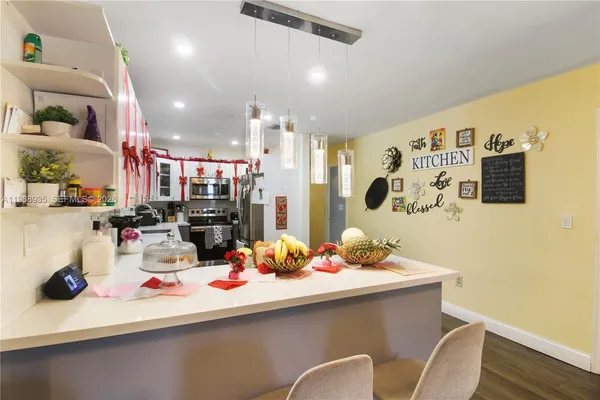 a room with stainless steel appliances kitchen island granite countertop a sink and cabinets