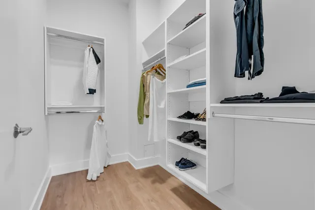 a view of walk in closet with clothes and shoes