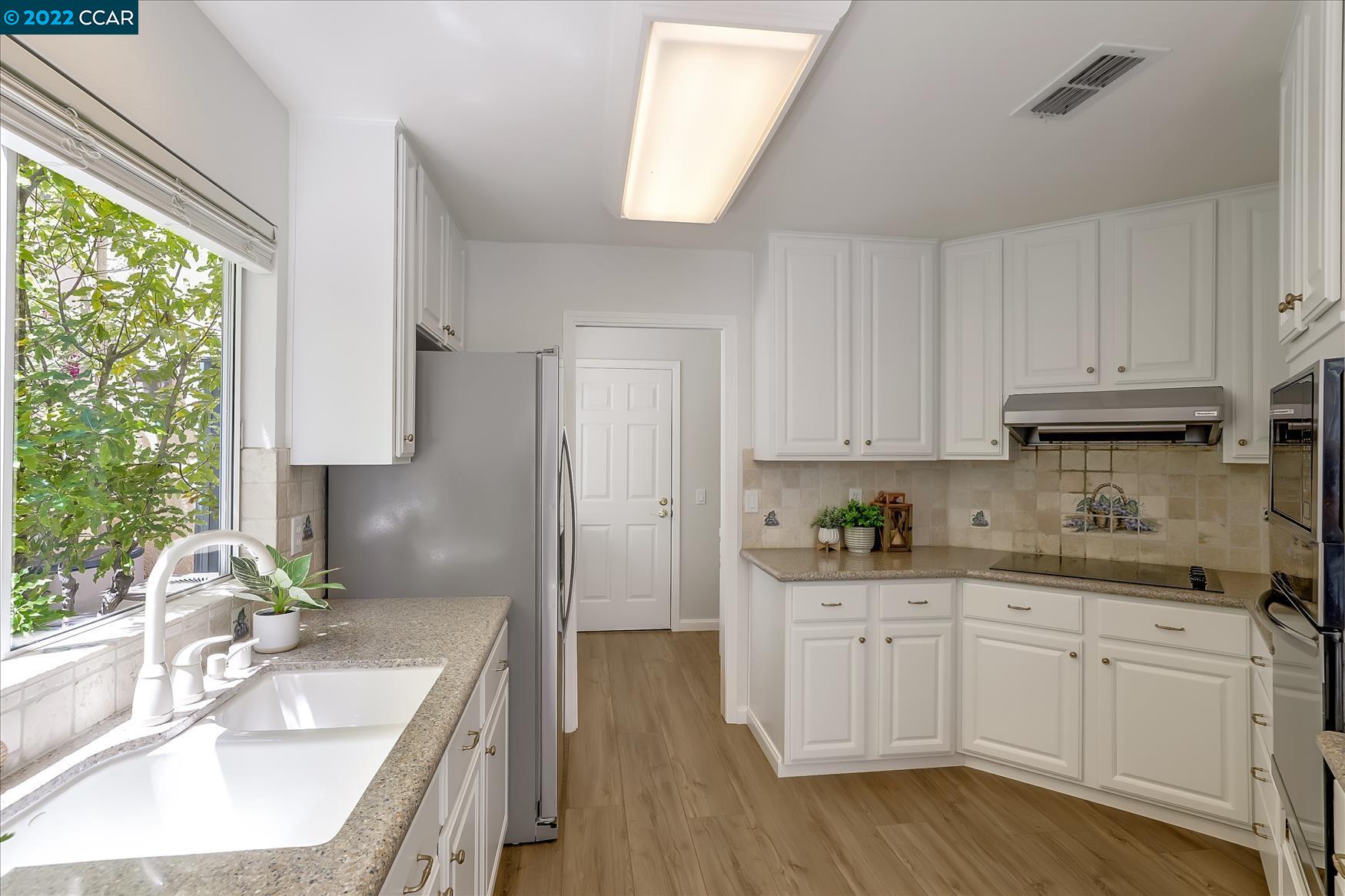 388 Catalan Way San Ramon, CA 94582 - Photo 14 of 52 a kitchen with a sink dishwasher stove and refrigerator with wooden floor