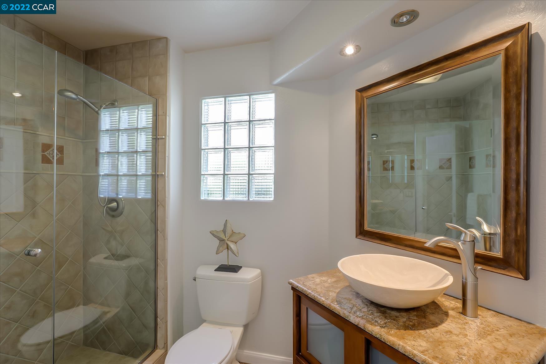 388 Catalan Way San Ramon, CA 94582 - Photo 35 of 52 a bathroom with a granite countertop sink toilet a mirror and shower