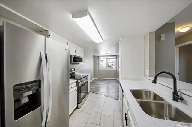 a kitchen with a refrigerator sink and cabinets