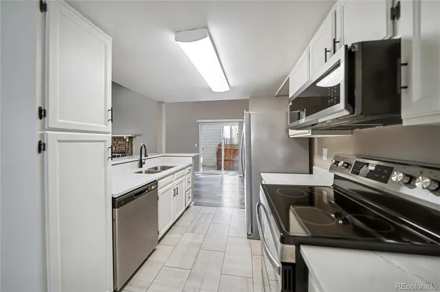 a kitchen with stainless steel appliances a sink stove and cabinets