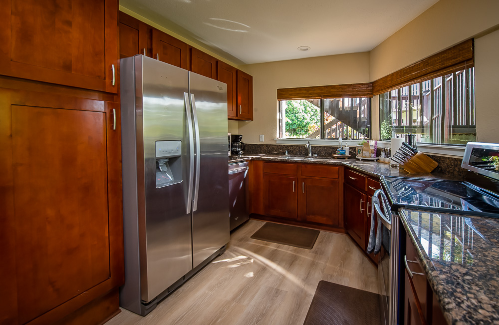 3920 Wyllie Road, Unit 9A Princeville, HI 96722 - Photo 11 of 30 a kitchen with stainless steel appliances granite countertop a refrigerator and a sink