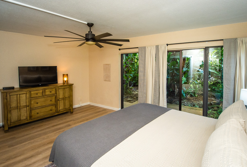 3920 Wyllie Road, Unit 9A Princeville, HI 96722 - Photo 15 of 30 a bedroom with a bed and a flat screen tv