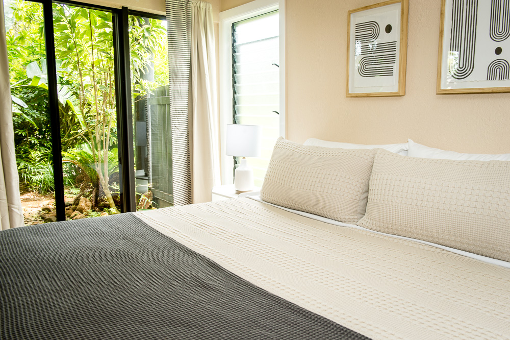 3920 Wyllie Road, Unit 9A Princeville, HI 96722 - Photo 16 of 30 a bedroom with a large bed and a large window