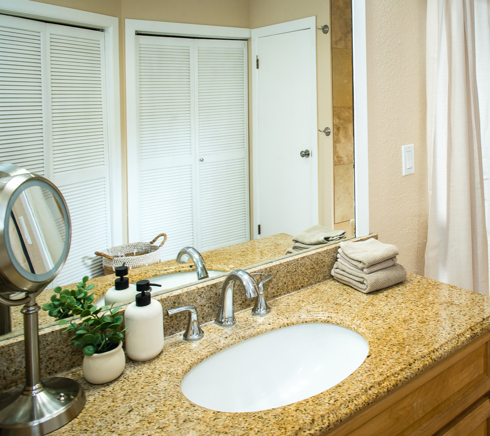 3920 Wyllie Road, Unit 9A Princeville, HI 96722 - Photo 19 of 30 a bathroom with a granite countertop sink and a mirror