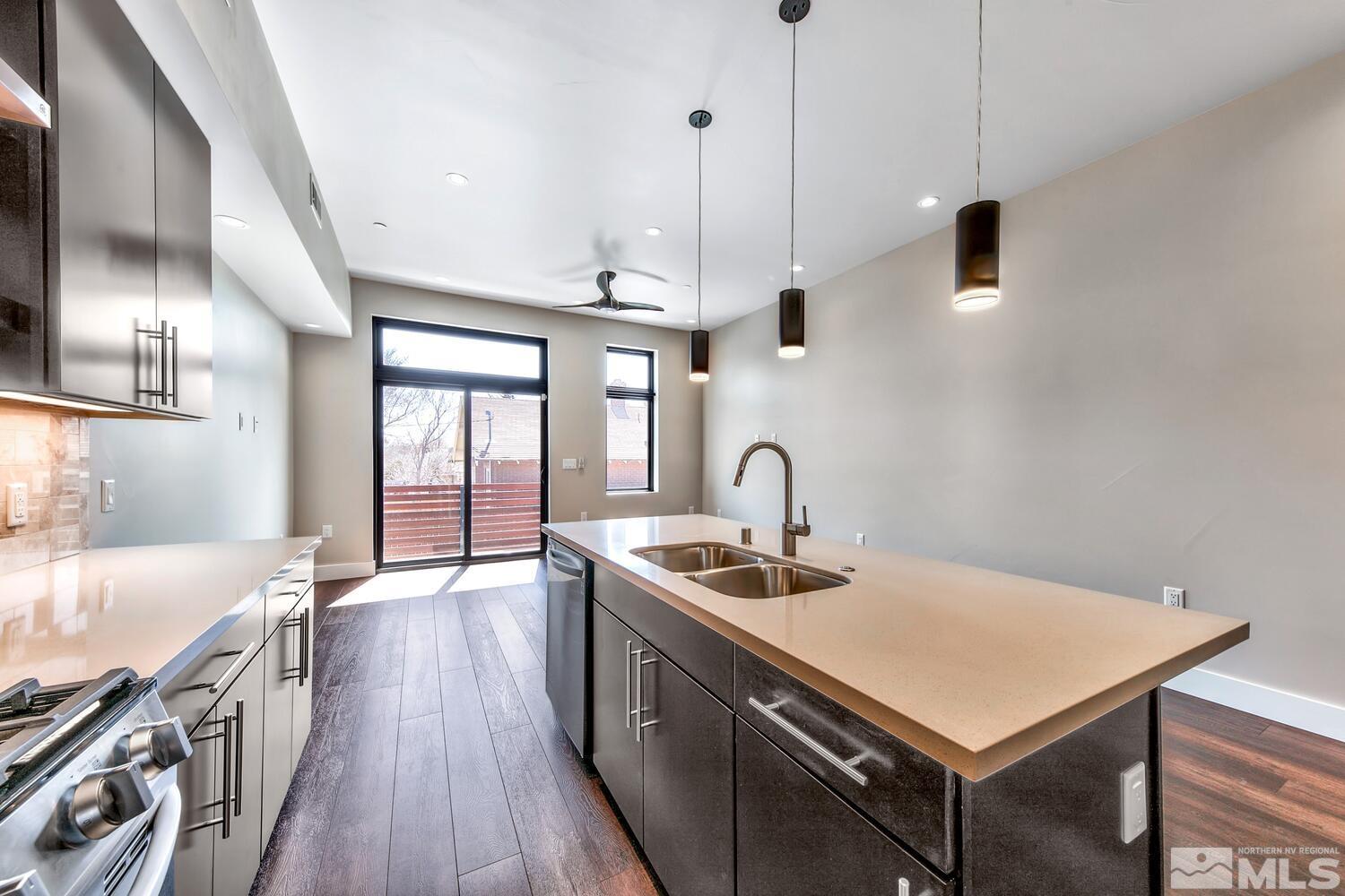 106 High Street Reno, NV 89502 - Photo 11 of 21 a kitchen with stainless steel appliances granite countertop a sink a stove and a wooden floor