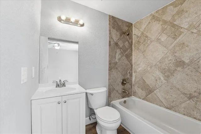 a bathroom with a bathtub shower sink vanity and toilet