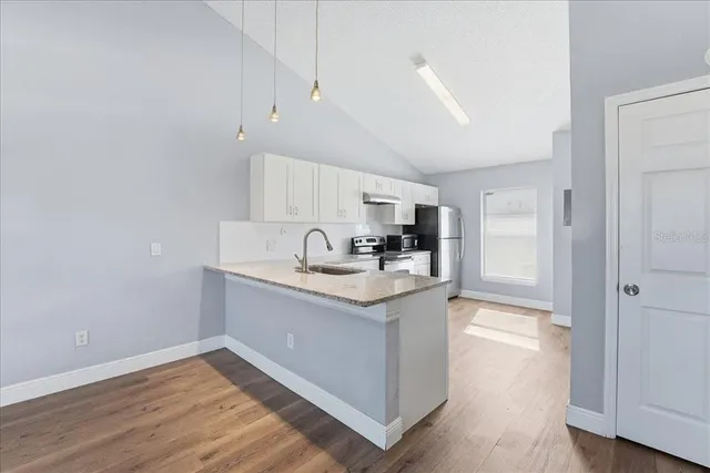a kitchen with granite countertop a sink and cabinets