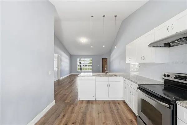 a kitchen with wooden floors and appliances