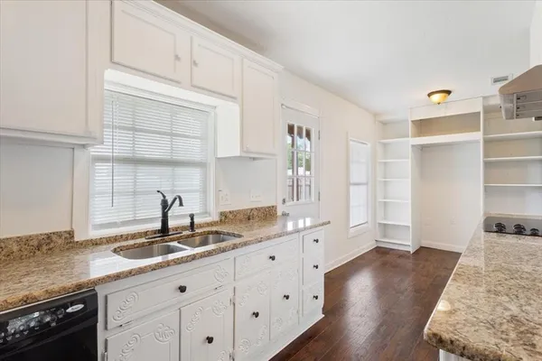 a kitchen with granite countertop a sink and a stove