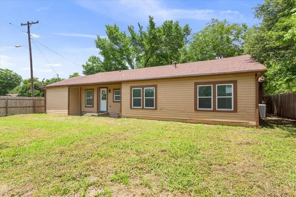 a house that has a big yard with wooden fence
