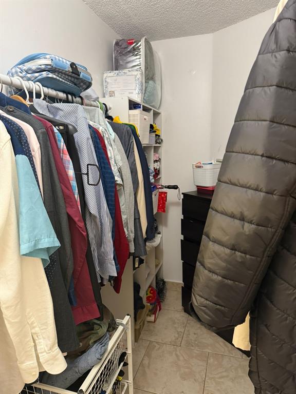 801 Lyons Road, Unit 19108 Coconut Creek, FL 33063 - Photo 14 of 42 a view of walk in closet with clothes and shoes