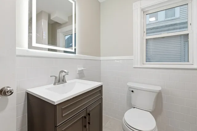 a bathroom with a toilet sink and mirror