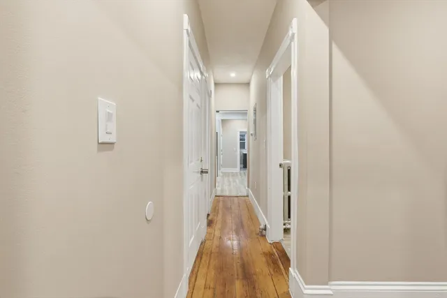 a view of a hallway with wooden floor