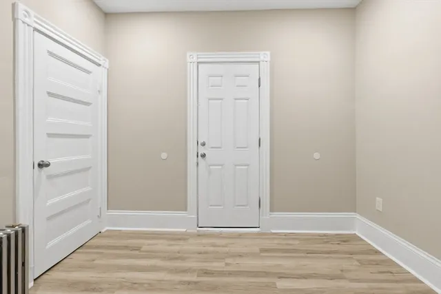 a view of an empty room with closet and a window