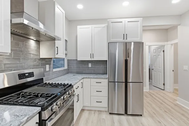 a kitchen with cabinets appliances and wooden floor