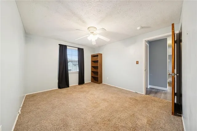 a view of an empty room with closet and a window