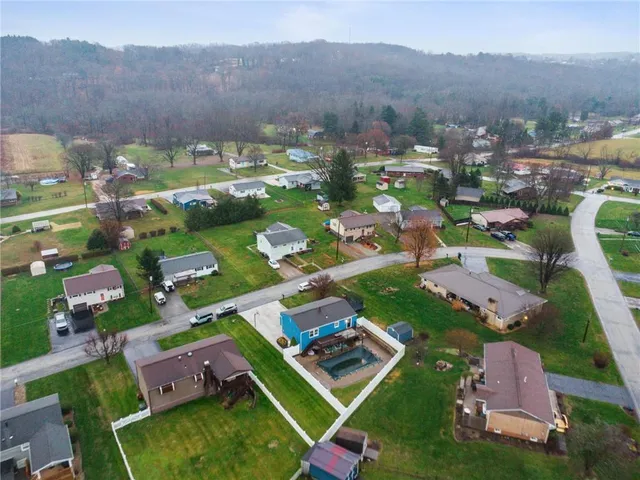 an aerial view of a city with lots of residential buildings and mountain view in back