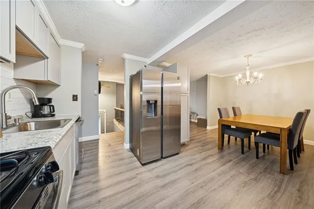 a kitchen with stainless steel appliances granite countertop a kitchen island hardwood floor a dining table and chairs