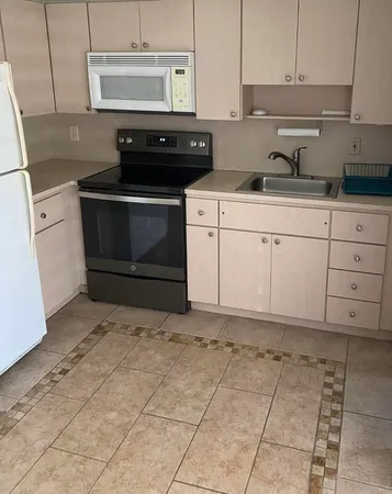 a kitchen with a stove top oven and cabinets