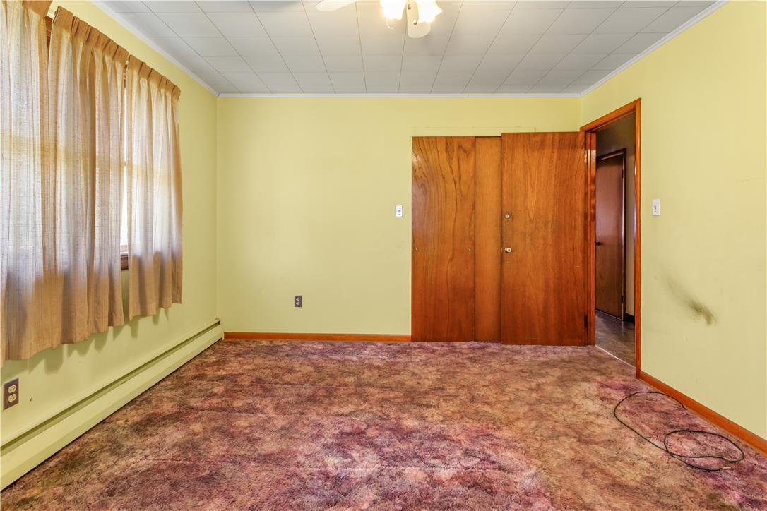 479 Cherry Hill Road Nazareth, PA 18064 - Photo 8 of 25 Plentiful natural light streams across this classic bedroom featuring patterned carpeting and wood paneling.