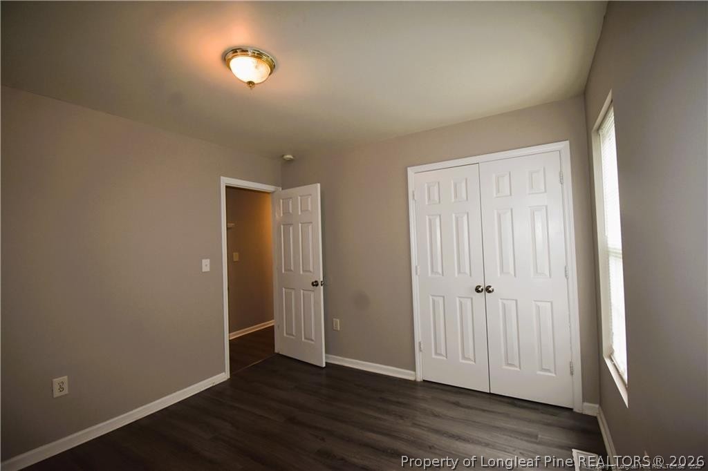 6158 Lonestar Road Fayetteville, NC 28303 - Photo 13 of 20 an empty room with wooden floor and windows