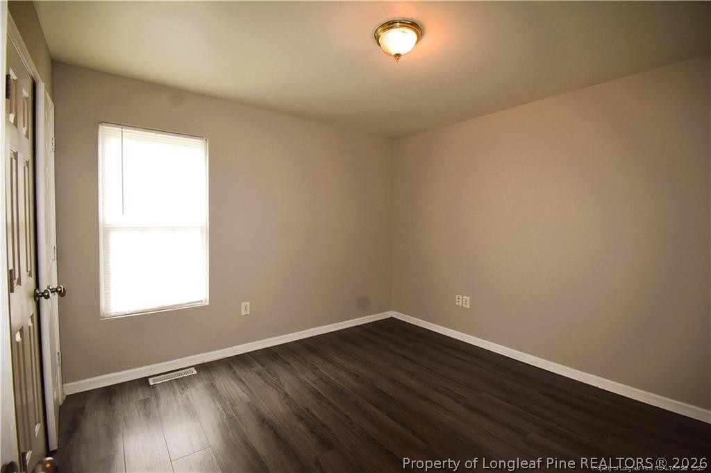 6158 Lonestar Road Fayetteville, NC 28303 - Photo 15 of 20 an empty room with wooden floor and windows
