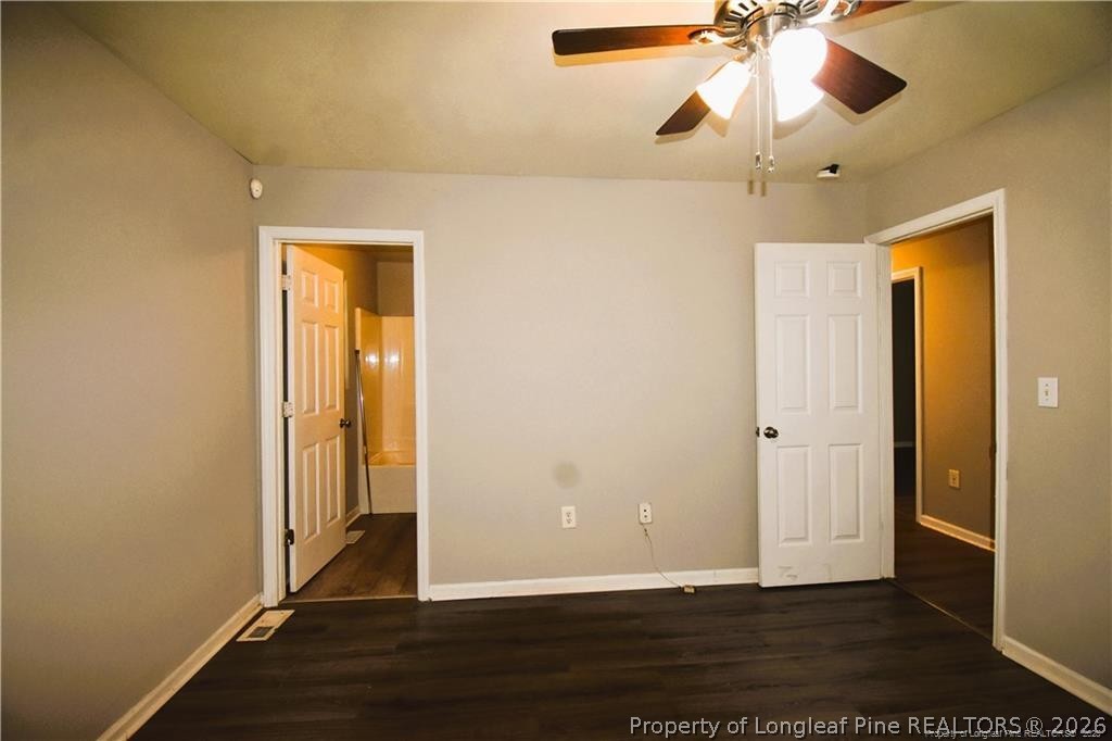 6158 Lonestar Road Fayetteville, NC 28303 - Photo 17 of 20 an empty room with wooden floor fan and windows