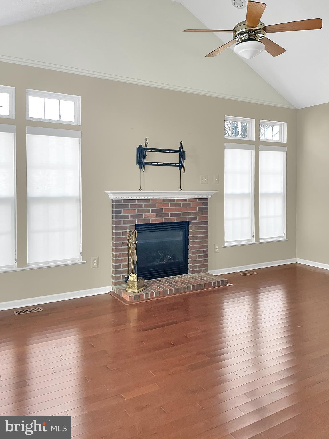 1747 Algonquin Road Frederick, MD 21701 - Photo 4 of 10 an empty room with wooden floor fireplace and windows