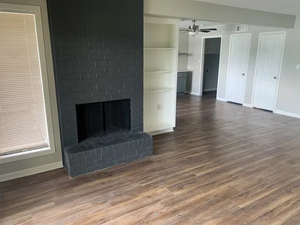 a view of a livingroom with wooden floor and staircase