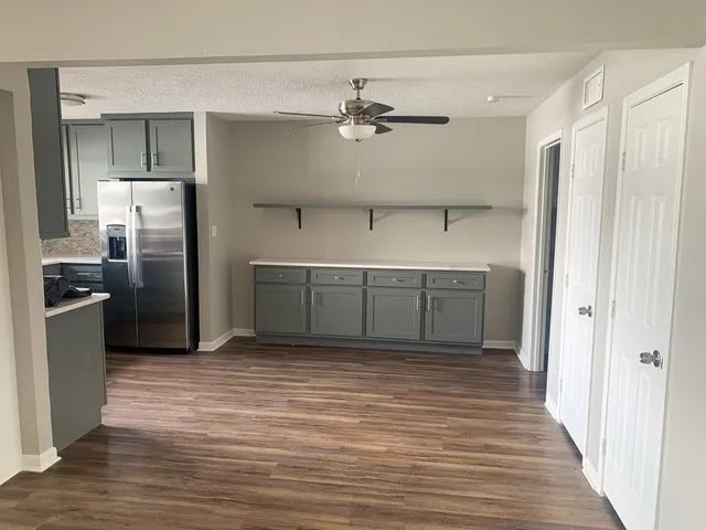 a view of a kitchen with a sink and refrigerator