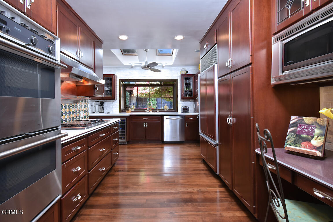 4727 Libbit Avenue Encino, CA 91436 - Photo 26 of 47 a kitchen with stainless steel appliances kitchen island granite countertop a refrigerator and a stove top oven